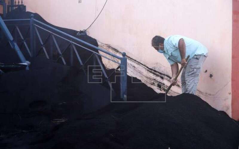 Foto de archivo de un hombre limpiando su vivienda de ceniza en Las Manchas, en La Palma / EFE / Luis G Morera.